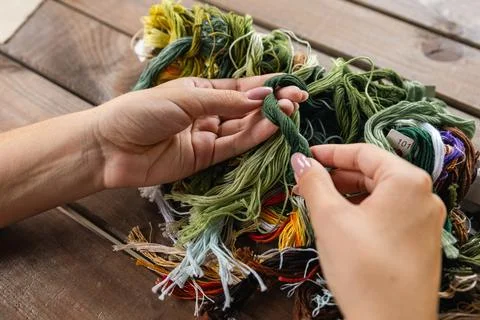 Close-up of hands sorting through a pile of embroidery floss. A large number  Stock Photos