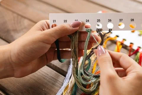 Close-up of hands sorting through a pile of embroidery floss. A large number  Stock Photos