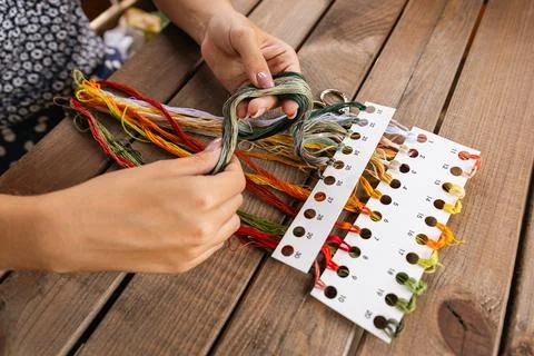 Close-up of hands sorting through a pile of embroidery floss. A large number  Stock Photos
