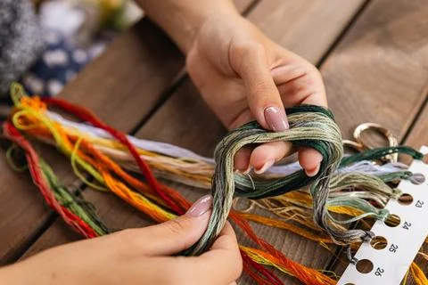 Close-up of hands sorting through a pile of embroidery floss. A large number  Stock Photos