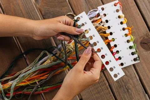 Close-up of hands sorting through a pile of embroidery floss. A large number  Stock Photos