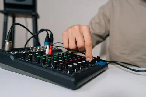 Close-up hands of sound engineer adjusting audio mixing console, tuning input Stock Photos