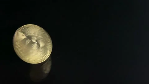 Close-up of hands spinning a bitcoin coin on a black surface. Concept of move Stock Footage 169643062