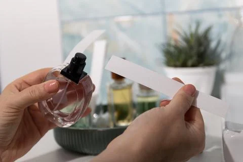 Close-up of hands spraying perfume onto blotter for fragrance testing at vani Stock Photos