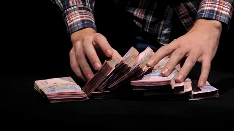 Close-up of hands spread on the table packs of Ukrainian hryvnia in slow motion. Video stock 129786617