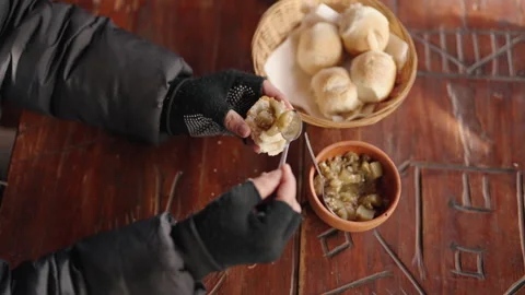 Close-Up of Hands Spreading Jam on Fresh Bread at Rustic Table Stock Footage 336259956