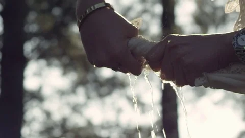 Close up of hands squeezes out wet clothes outdoors Stock Footage 72753892