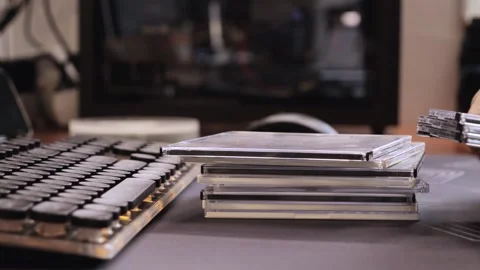 Close up of hands stacking CD cases near retro keyboard on desk in home office Stock-Footage 312370323