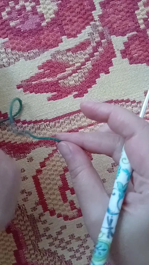 Close-up of hands starting to crochet with deep green yarn Stock Footage 343782507