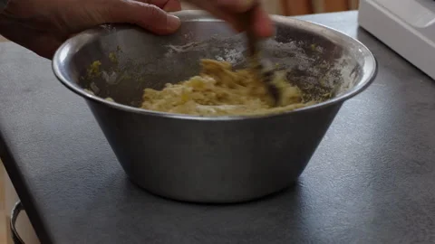 Close up of hands stirring yellow split pea dough with a wooden spoon in a .. Stock-Footage 347078722