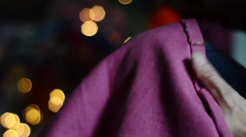 Close up hands stitching dusky pink fabric with cosy, glowing background Stock Footage 66427067