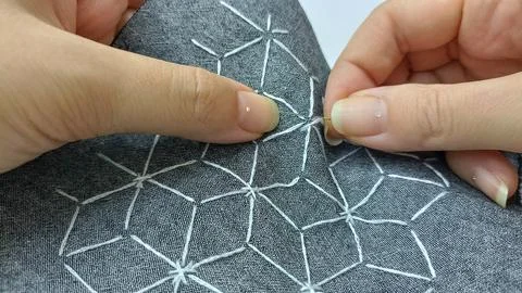 Close-up of hands stitching sashiko geometric embroidery pattern Foto stock