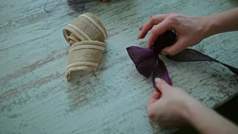 Close-up hands straighten a bow made of decorative ribbon. Stock Footage 163348987