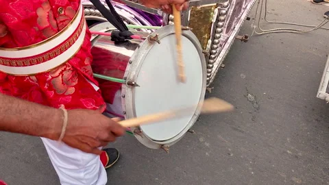 Close-up of hands striking drum outdoors with vibrant festival colors 스톡 동영상 333263519