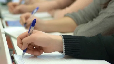 Close-up of hands of students writing in the notebooks Stock Footage 75556135