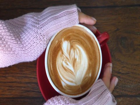 Close Up Hands In Sweater Holding Cup With Coffee Latte Stockbeeldmateriaal 81623025