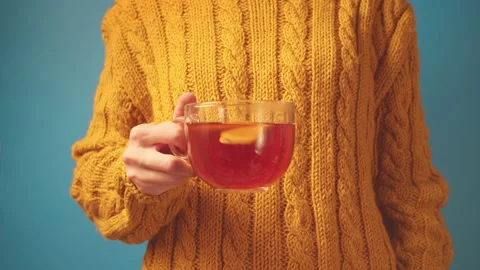 Close-up hands in sweater holding cup tea with lemon and ginger, stirring tea Stock-Footage 136855264