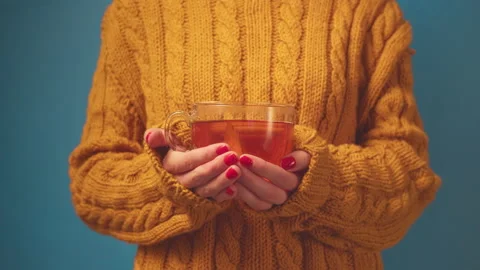 Close-up hands in sweater holding cup and drink tea with lemon and ginger on Video stock 136855812