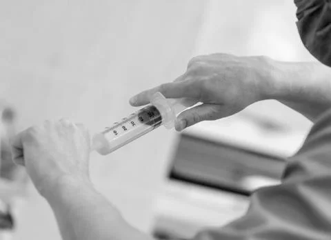 Close-up of hands with a syringe. Stock Photos