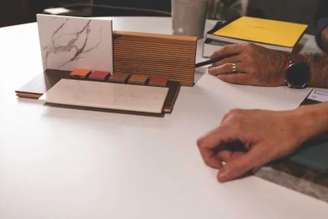 Close up of hands on the table during an office presentation with three young Stock Photos