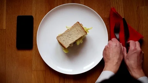 Close-up of the hands on the table with a sandwich on the cell phone. Stock Footage 125207610
