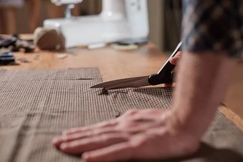 Close-up hands of Tailor, cutting wool fabric. Craftsman Makes rectangular Foto stock
