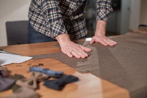 Close-up hands of Tailor, cutting wool fabric. Craftsman Makes rectangular Stock Photos