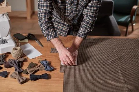 Close-up hands of Tailor, cutting wool fabric. Craftsman Makes rectangular Stock Photos