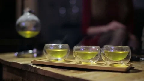 Close up hands take small cups of tea at tea ceremony Stock Footage 73274394