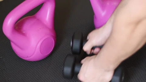 Close up hands taking dumbbells on black fitness zone Stock Footage 237729261