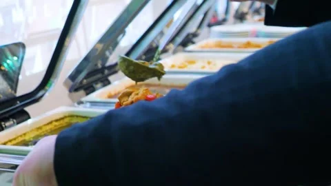 Close-up of hands taking food from a self service buffet line in a restaurant. 스톡 동영상 328307564