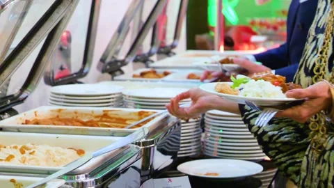 Close-up of hands taking food from a self service buffet line in a restaurant. Stock-Footage 328307578