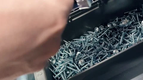 Close up of hands taking metal screws from a storage container and putting .. Stock Footage 345097536