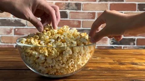 Close up of hands taking popcorn from bowl. Stock Footage 118968720