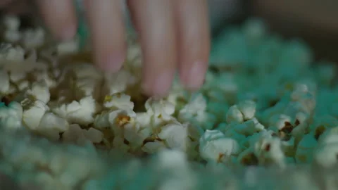 Close up of hands taking popcorn from the plate. Movie night at home Video stock 262947783