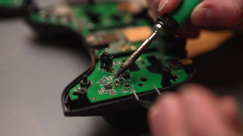 Close-up hands of technician using soldering iron to repair circuit board inside Stock Footage 305514758