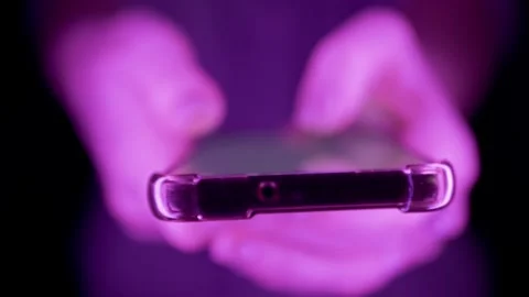 Close Up Hands Texting On Mobile Phone In Dark Pink Neon Light Vídeos de archivo 330176562