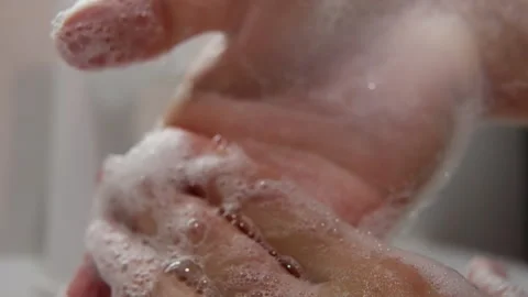 Close-up of hands thoroughly washing with soap under running water, building Stock Footage 317544638