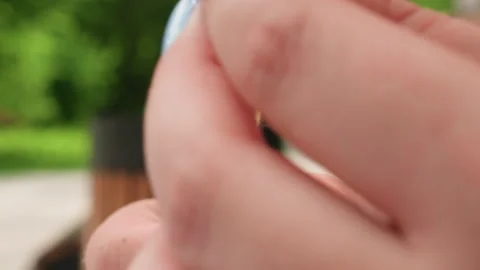 Close Up Hands Threading Needle Outdoors in Park Stock Footage 326032335