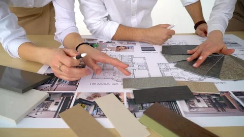 Close up hands of three workers discussing building drawings in office. Closeup Stock Footage 88635390