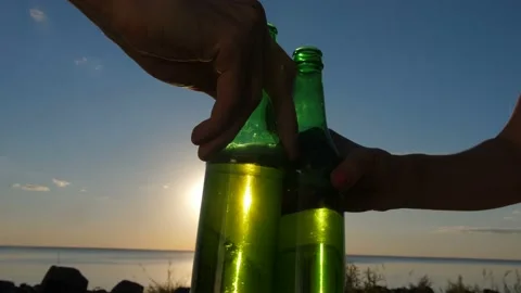 Close-up hands toasting beer bottles at sunset Stock Footage 101222207