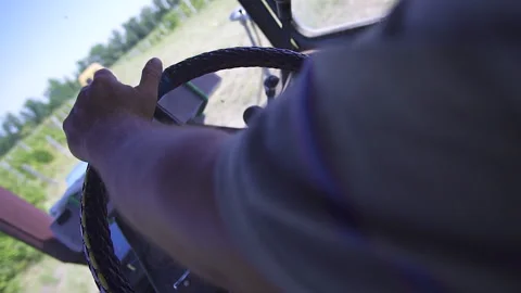 Close-up of the hands of the tractor driver, who is driving through the fields,  Stock Footage 155464825