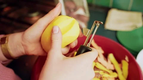 Close-up hands trimming a bad spot from a yellow potato using a vegetable Video stock 328850913