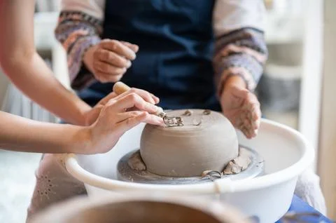 Close Up Hands Trimming Base of Inverted Clay Bowl with Loop Tool in potter.. Stock Photos