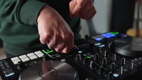 Close up hands turning knobs and pushing buttons on sound mixing board at home Stock Footage 232660145