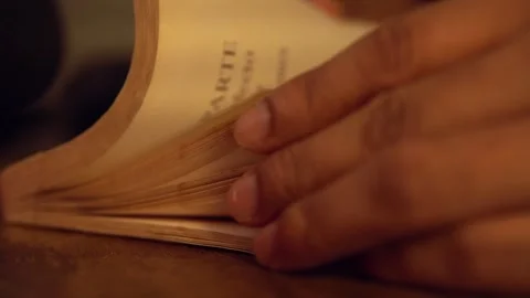 Close up of hands turning pages of an old book at night Stock Footage 320967290