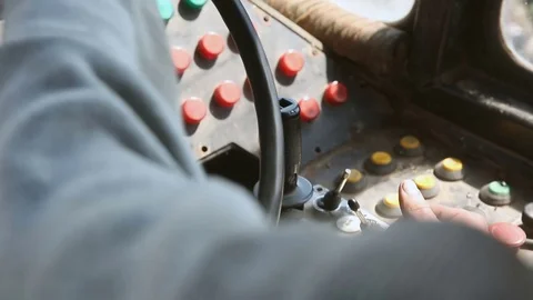 Close-up of hands turning the steering wheel of an old bulldozer. Tractor Stockbeeldmateriaal 76200461