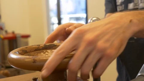 Close-up of hands turns controls on a three-role refiner in chocolate factory. Stock Footage 100646499