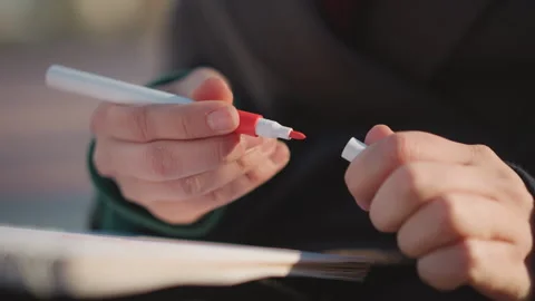 Close up of hands twisting red capped white marker to reveal ink for creative Stock-Footage 346656619
