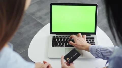 Close-up hands of two girlfriends enter credit card details to make an online Stock Footage 119075127